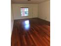 Bright living room with hardwood floors, a window overlooking the yard, and a neutral color palette at 507 Bates Ave, Eustis, FL 32726