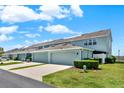 Townhomes with garages and driveways offer ample parking space on a beautiful sunny day at 534 Juniper Springs Dr, Groveland, FL 34736