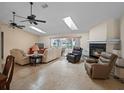 Bright living room featuring a fireplace, comfortable seating, skylights, and a sliding glass door at 5712 Connors St, Leesburg, FL 34748