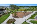 Community playground featuring swings, slide, and shade structure with green landscaping at 6484 Barnstorm Way, St Cloud, FL 34771