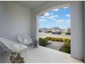 Inviting covered front porch with modern seating, perfect for relaxing outdoors at 6816 Perch Hammock Loop, Groveland, FL 34736