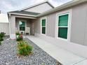 Inviting home entrance featuring a walkway, white trim windows, and rock landscaping with flowers at 7394 Lussier Ct, The Villages, FL 34762