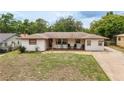 Single-story home featuring a covered porch and well-maintained lawn at 800 Jefferis Ct, Eustis, FL 32726
