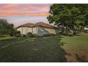 Green backyard featuring mature trees, lush lawn, and view of the home's rear exterior at 802 San Salvador Dr, The Villages, FL 32159