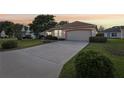 Well-maintained single-story home with long driveway, lush lawn, and attached two-car garage at 802 San Salvador Dr, The Villages, FL 32159