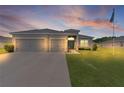 Exterior view of home with three-car garage under a dusk sky with beautiful cloud formations at 8978 Se 42Nd Ct, Ocala, FL 34480