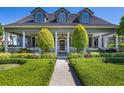 Charming home with a lush front yard and welcoming porch with columns at 9648 Weatherstone, Windermere, FL 34786