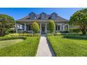 Inviting home featuring a classic design, landscaped yard, and a spacious front porch at 9648 Weatherstone, Windermere, FL 34786