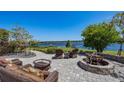 Inviting outdoor stone patio featuring wicker seating, fire pit, and tranquil lake views for relaxation and entertainment at 9648 Weatherstone, Windermere, FL 34786