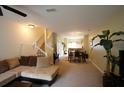 Spacious living room featuring neutral carpet, a staircase, and an open layout leading to the dining area at 10115 Regent Park Dr # 2503, Orlando, FL 32825