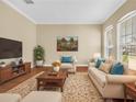 Living room with neutral furniture, hardwood floors, and bright windows at 108 Whispering Pines Way, Davenport, FL 33837