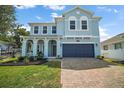 Stunning exterior elevation with a brick paver driveway leading up to the spacious two car garage at 1155 Dora Parc Ln, Mount Dora, FL 32757
