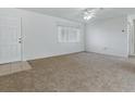 Bright living room with neutral carpet, ceiling fan, and a large window at 13875 Se 97Th Ave, Summerfield, FL 34491