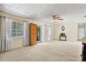 Bright living room with large windows, neutral carpet and a view of the front yard at 1416 Abigail Dr, Apopka, FL 32703