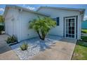 Property featuring an inviting entryway with clean white stone accents and palm trees at 1722 Moreno Pl, The Villages, FL 32159