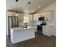 Modern kitchen features stainless steel appliances, island with sink, and pendant lighting at 2 Pine Terrace Way, Ocala, FL 34472