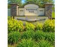 Beautiful Westridge Park entrance sign surrounded by lush green landscaping and colorful plants at 2106 Elio Ridge Dr, Zellwood, FL 32798