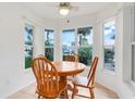 Cozy dining area with a round wooden table surrounded by large windows at 21226 Royal St Georges Ln, Leesburg, FL 34748