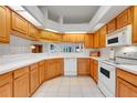 Bright kitchen featuring wooden cabinets, white countertops, and modern appliances at 21226 Royal St Georges Ln, Leesburg, FL 34748