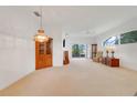 Spacious living room with carpet, light walls, and sliding glass doors leading to the outside at 21226 Royal St Georges Ln, Leesburg, FL 34748