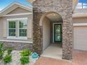 Inviting front entrance featuring a stone archway and beautifully landscaped garden at 224 Silver Maple Rd, Groveland, FL 34736