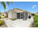 This home showcases a screened lanai, spacious concrete patio, and attached garage at 2457 Upton St, The Villages, FL 32163