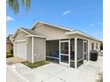 Back of single-story home featuring a screened-in patio and a concrete patio, ideal for outdoor living at 2457 Upton St, The Villages, FL 32163