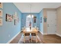 Bright dining room with wooden table, chairs, rug, colorful decor, and blue accent wall at 27215 White Plains Way, Leesburg, FL 34748