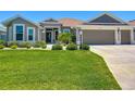 Well-maintained single-story home with a three-car garage and lush green lawn at 3138 Aurea Pl, The Villages, FL 32163