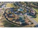 Bird's-eye view showcasing the community pool, tennis courts, and surrounding neighborhood at 3194 Bayou Ln, Tavares, FL 32778