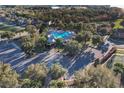 Aerial view of the community pool area, featuring palm trees, a gazebo, and tennis courts at 3194 Bayou Ln, Tavares, FL 32778