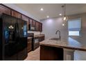 Modern kitchen with stainless steel appliances, dark wood cabinets, and a granite countertop island at 3194 Bayou Ln, Tavares, FL 32778