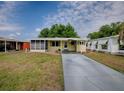 Inviting home with a screen enclosed porch, concrete driveway, green shutters, and well-manicured landscaping at 32521 W Golf Ct, Leesburg, FL 34748