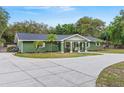 Well-maintained single-story home showcasing a spacious driveway and lush greenery, enhancing its curb appeal at 39812 French Rd, Lady Lake, FL 32159