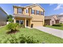 Two-story home featuring a manicured front yard and a spacious driveway leading to an attached two-car garage at 422 Rock Springs Cir, Groveland, FL 34736