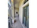 View of covered porch and doorway with glass panel in light blue door at 5300 Treasure View Way, Leesburg, FL 34748