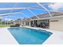 Sparkling screened-in pool with solar panels on the roof and outdoor seating area at 5400 Saddleback Ct, Lady Lake, FL 32159