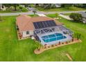 Aerial view of a screened-in pool area and solar panels on the roof of this well-maintained home at 5400 Saddleback Ct, Lady Lake, FL 32159