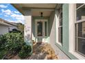 Inviting front entrance with decorative glass door, stone tile, and lush landscaping at 5604 Gulf Stream St, Tavares, FL 32778