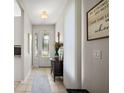 Well-lit hallway with tile flooring, leading to the decorative front door with glass panels at 5604 Gulf Stream St, Tavares, FL 32778