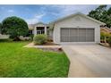 Charming single-story home with a well-maintained lawn and an attached two-car garage at 712 Old Oaks Ln, Leesburg, FL 34748