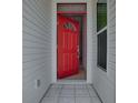 Welcoming foyer with a red front door, tiled floor, and neutral interior walls at 712 Old Oaks Ln, Leesburg, FL 34748