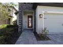 Front entry with stone pillar and glass paneled door next to the 2 car garage at 7955 Delwin Ln, Reunion, FL 34747