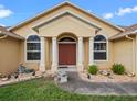 Close-up of the front entrance showcasing a double-door entry with decorative columns and landscape details at 847 Cumberland Cir, Minneola, FL 34715