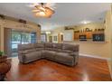 Open living room features beautiful floors, sliding glass doors, and large sectional sofa at 847 Cumberland Cir, Minneola, FL 34715