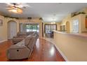 Bright living room with wood floors opens to breakfast nook and features slider to outdoor living at 847 Cumberland Cir, Minneola, FL 34715