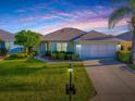 Charming single story home showcasing manicured landscaping, lush green lawn and an attached two car garage at 8601 Se 133Rd St, Summerfield, FL 34491
