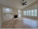 Bright living room with built-in shelves, a fireplace, plantation shutters, and tile flooring at 8719 Kenmure Cv, Orlando, FL 32836