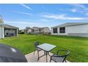 View of the backyard showing an outdoor seating area, with a clear view of neighboring properties at 965 Eastmont Ct, The Villages, FL 32162