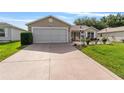 Charming single-story home with a well-manicured lawn and an attached two-car garage at 965 Eastmont Ct, The Villages, FL 32162